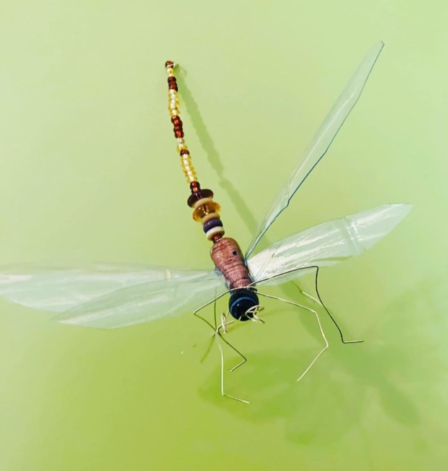 Insekt lavet af ståltråd og perler på grøn baggrund, foto Annette Hammer