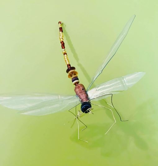Insekt lavet af ståltråd og perler på grøn baggrund, foto Annette Hammer