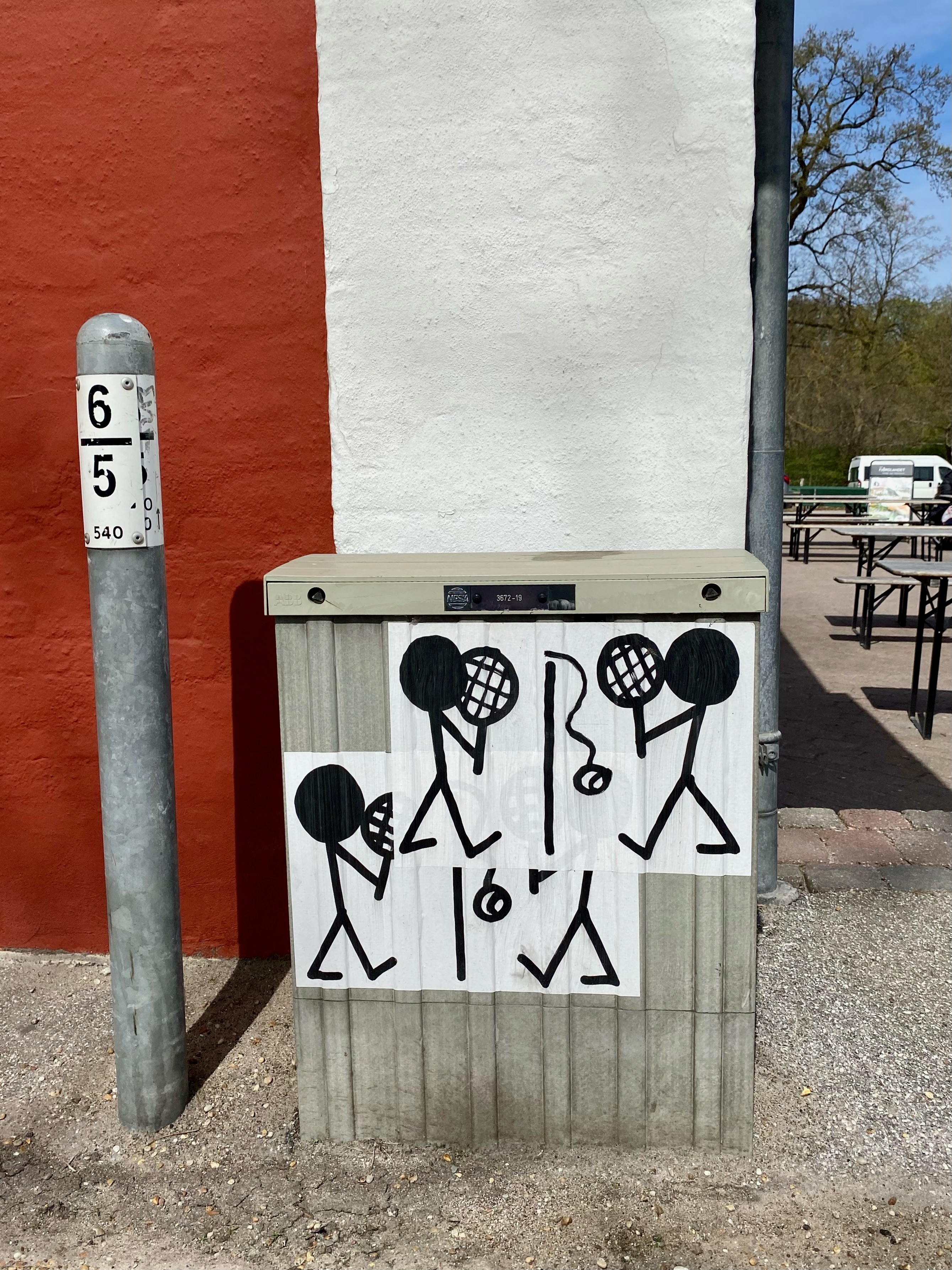 billede af en elboks på gaden med to pindemænd som spiller stangtennis